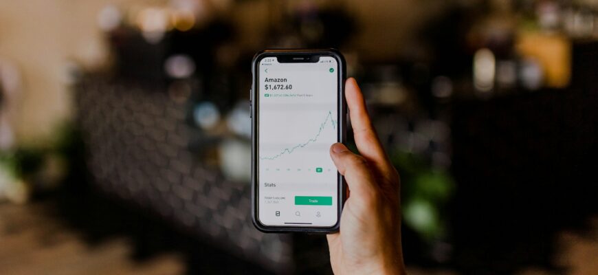 person holding black iPhone displaying stock exchange